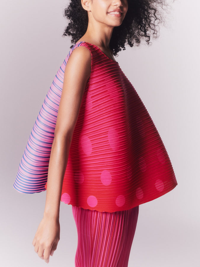 Closeup of model wearing VEGE MIX 1 top and trousers in pink and red. Shot from the side, knees up to shoulders.