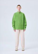 A model wears the HOMME PLISSÉ ISSEY MIYAKE RUSTIC KNIT trousers.