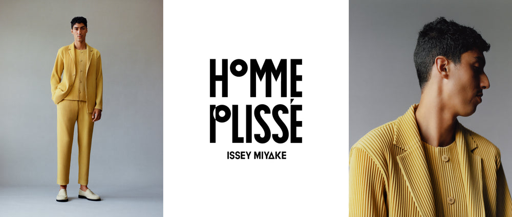 Model wearing TAILORED PLEATS 1 Jacket, Vest and Trousers in Mustard with beige loafers. Left: Model standing with hand in right pocket. Middle: HOMME PLISSÉ ISSEY MIYAKE logo in black on white background. Right: Close-up of model from chest up with head facing left.