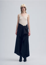 A model wears the ISSEY MIYAKE  ENCLOTHE PANTS trousers