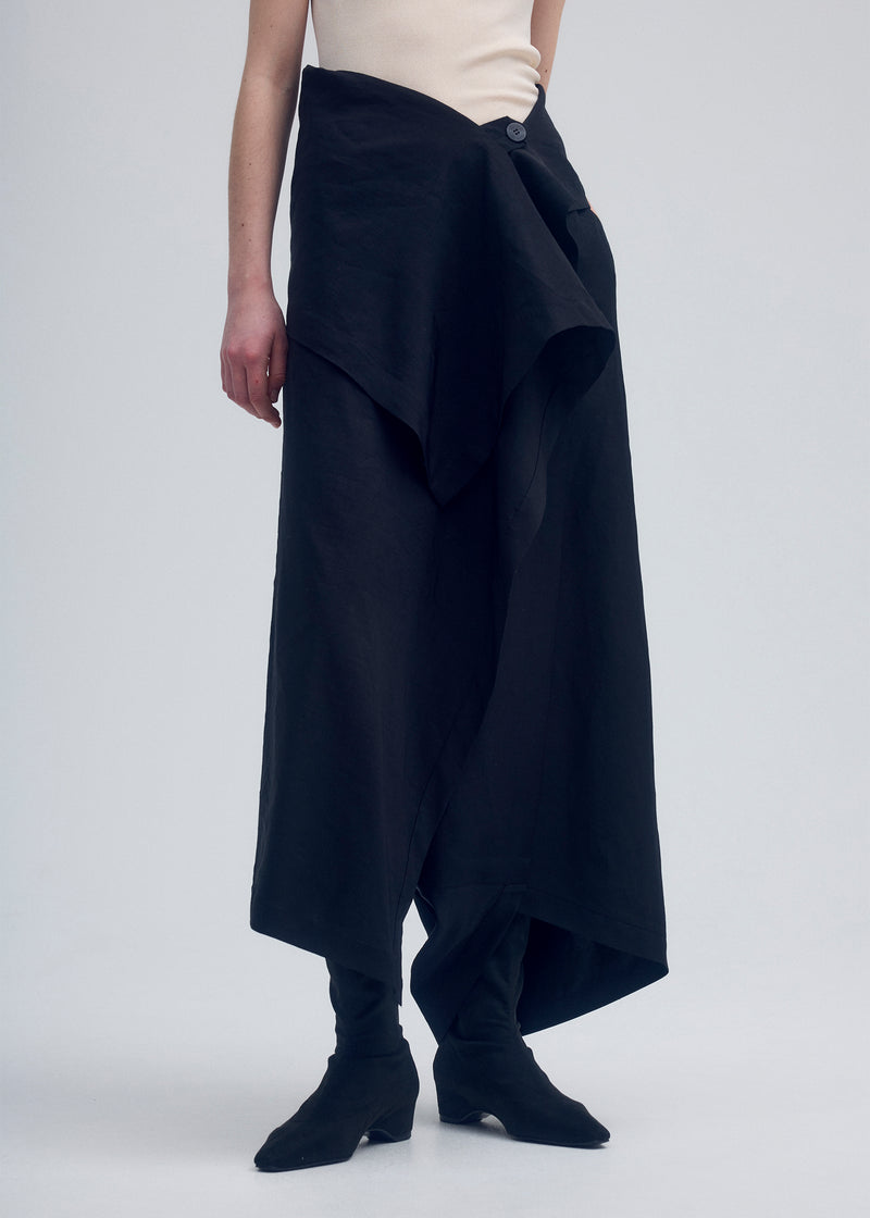 A model wears the ISSEY MIYAKE  ENCLOTHE PANTS trousers