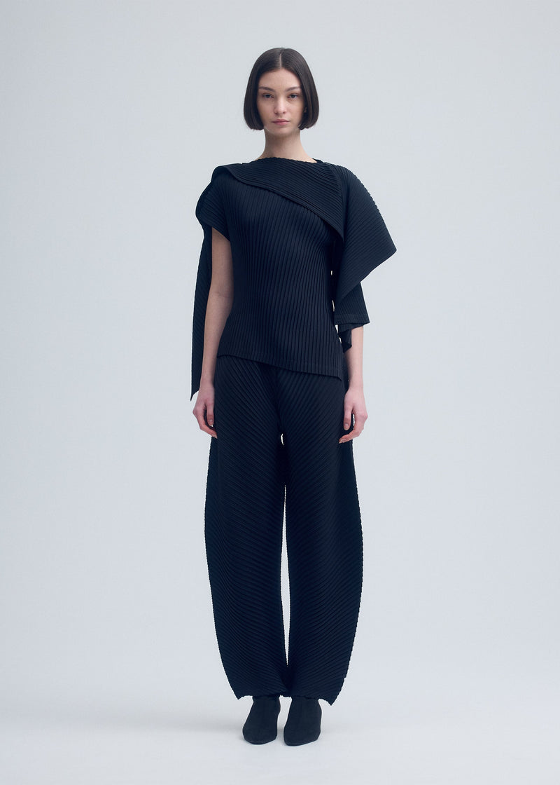 A model wears the ISSEY MIYAKE VIGOR PLEATS SOLID trousers.