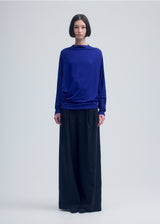 A model wears the ISSEY MIYAKE  WIND SMOOTH JERSEY top