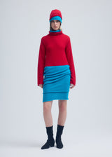 A model wears the ISSEY MIYAKE INTERPLAY tunic.