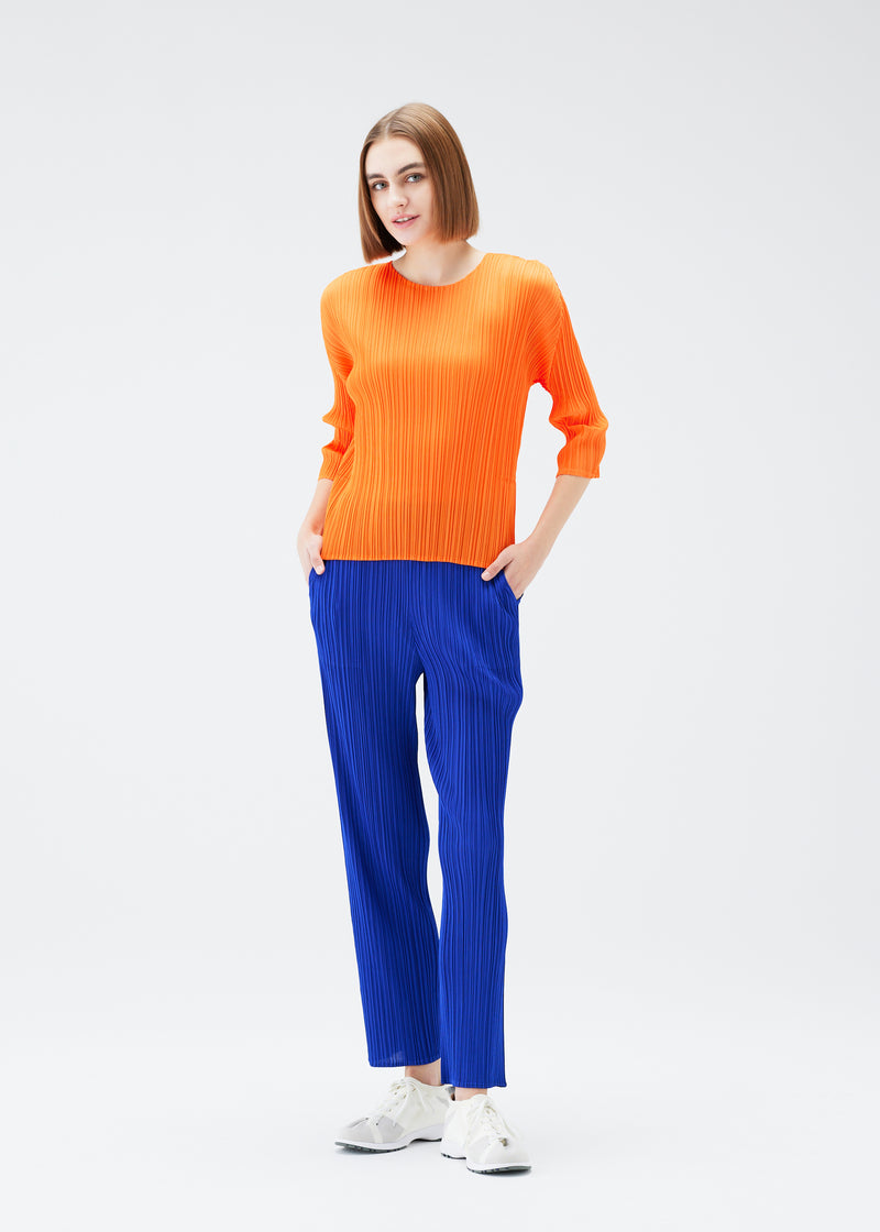 A model wears the PLEATS PLEASE ISSEY MIYAKE  MONTHLY COLORS JULY trousers