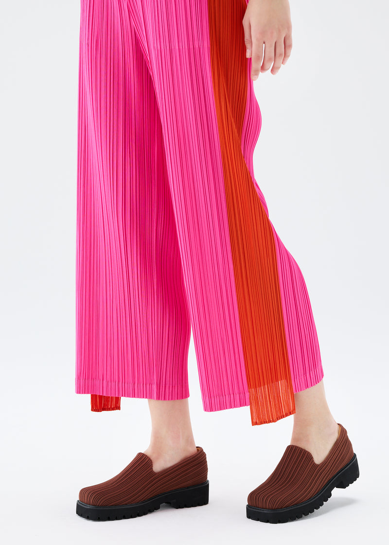 A model wears the PLEATS PLEASE ISSEY MIYAKE  COMET trousers