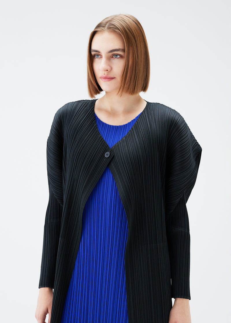 A model wears the PLEATS PLEASE ISSEY MIYAKE  MONTHLY COLORS JULY cardigan