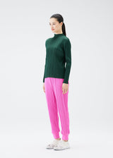 A model wears the PLEATS PLEASE ISSEY MIYAKE CREPE KNIT trousers.