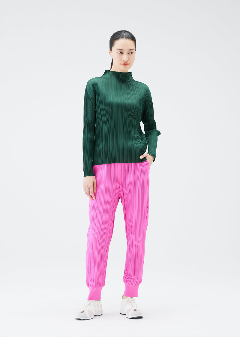 A model wears the PLEATS PLEASE ISSEY MIYAKE CREPE KNIT trousers.