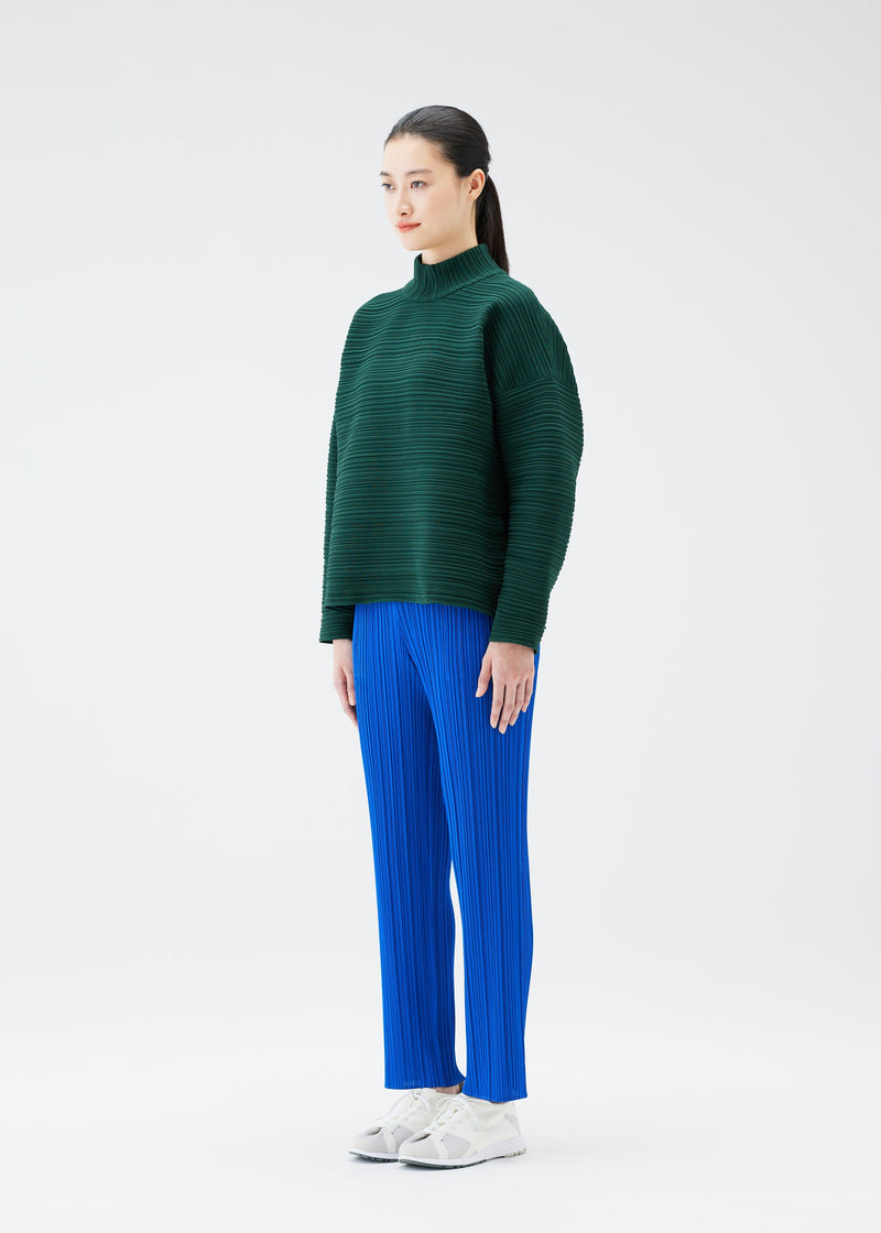 A model wears the PLEATS PLEASE ISSEY MIYAKE CREPE KNIT top.